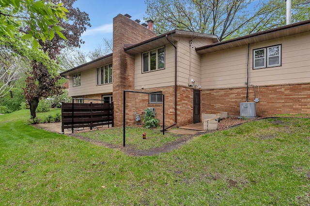 2916 Golf View Ct, Saint Cloud, MN 56301 - view of home's exterior with brick siding, cooling unit, a lawn, and a chimney