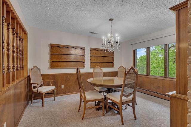 2916 Golf View Ct, Saint Cloud, MN 56301 - carpeted dining space featuring baseboard heating, a textured ceiling, a chandelier, wainscoting, and wood walls
