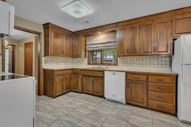 2916 Golf View Ct, Saint Cloud, MN 56301 - kitchen featuring white appliances, a sink, light countertops, and brown cabinetry