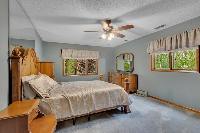 2916 Golf View Ct, Saint Cloud, MN 56301 - carpeted bedroom with a baseboard heating unit, multiple windows, baseboards, a textured ceiling, and a ceiling fan