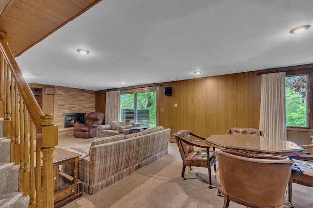 2916 Golf View Ct, Saint Cloud, MN 56301 - living area featuring a large fireplace, wood walls, healthy amount of natural light, light carpet, and stairs