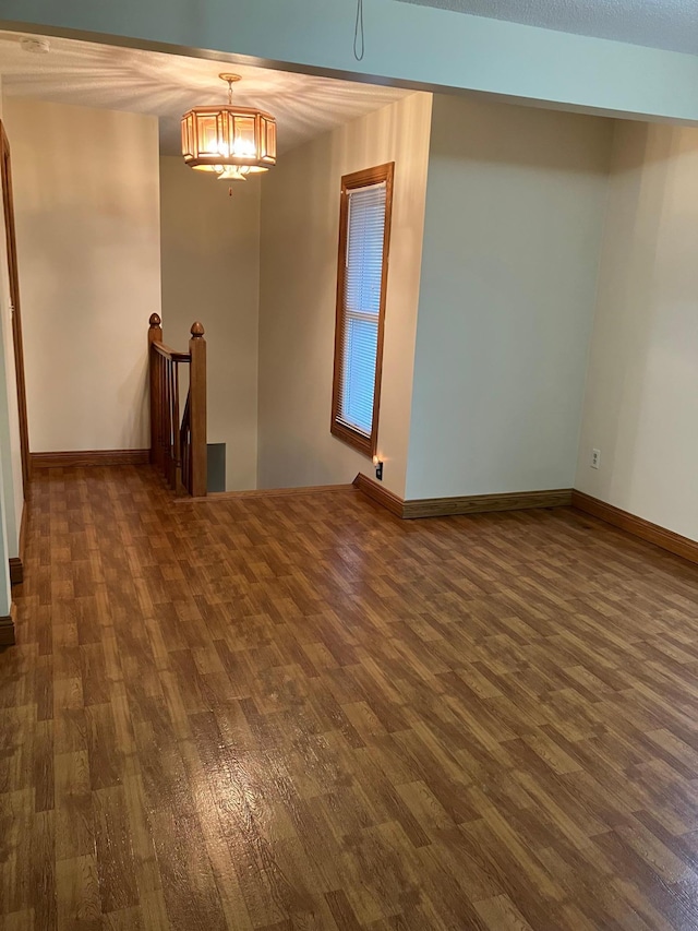 903 2nd St, Princeton, MN 55371 - spare room featuring dark wood-style floors, baseboards, and a chandelier