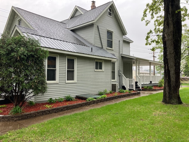 903 2nd St, Princeton, MN 55371 - view of front of home with a front lawn, roof with shingles, central AC unit, and covered porch
