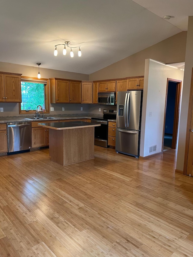 205 Darling Pl, Alexandria, MN 56308 - kitchen with stainless steel appliances, lofted ceiling, a sink, light wood-style floors, and brown cabinets
