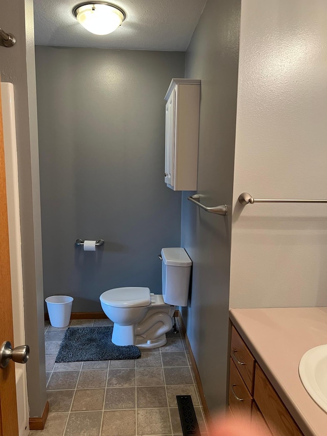205 Darling Pl, Alexandria, MN 56308 - bathroom with toilet, vanity, tile patterned flooring, a textured ceiling, and baseboards