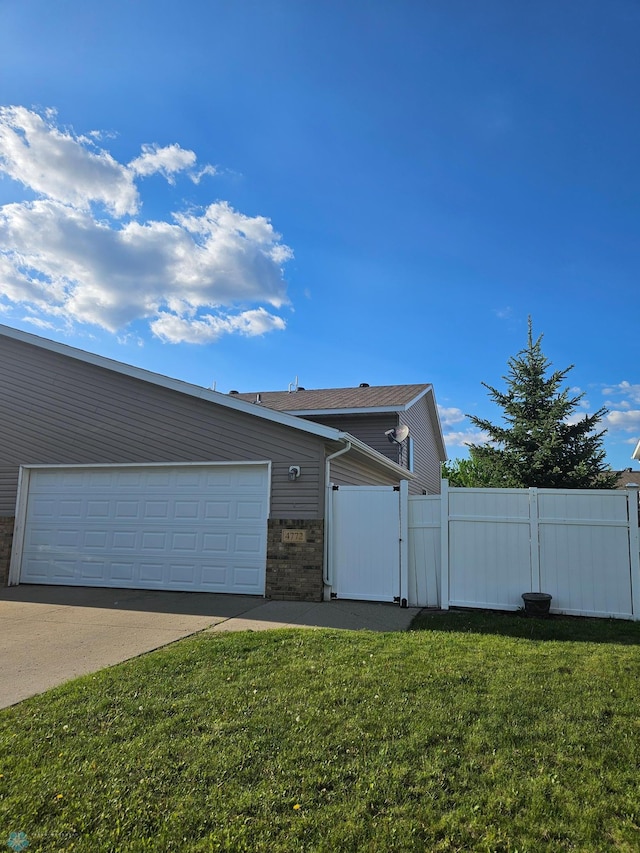 4772 Townsite Pl S, Fargo, ND 58104 - view of front facade with a garage, concrete driveway, a gate, and brick siding