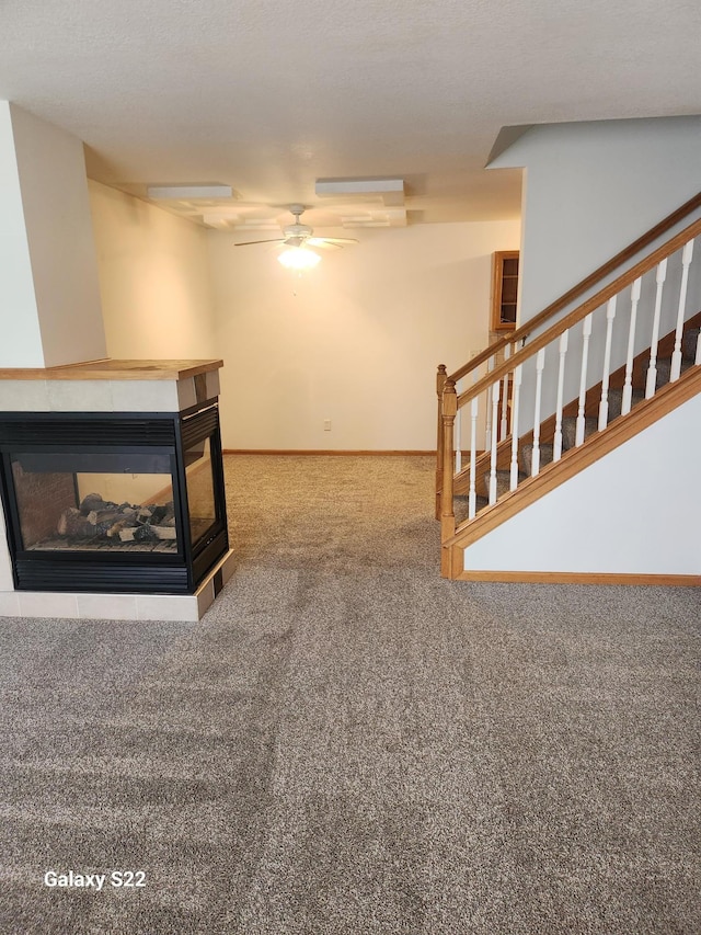 6454 Appaloosa Ave S, Forest Lake, MN 55025 - unfurnished living room with a multi sided fireplace, stairs, carpet flooring, and a ceiling fan