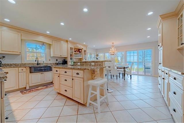 28320 State Highway 65, Pengilly, MN 55775 - kitchen with cream cabinets, a chandelier, light stone counters, glass insert cabinets, and a breakfast bar area