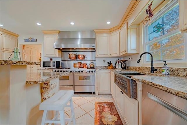 28320 State Highway 65, Pengilly, MN 55775 - kitchen featuring wall chimney range hood, stainless steel appliances, light tile patterned floors, light stone countertops, and recessed lighting