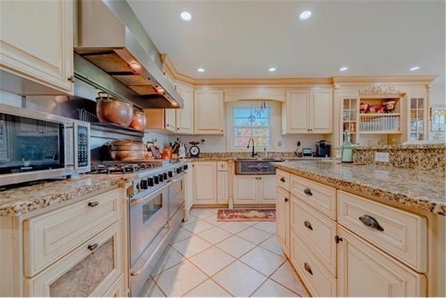 28320 State Highway 65, Pengilly, MN 55775 - kitchen featuring cream cabinetry, range hood, stainless steel appliances, a sink, and light stone counters