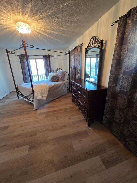 28320 State Highway 65, Pengilly, MN 55775 - bedroom with light wood finished floors and a textured ceiling