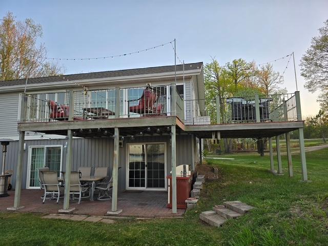 28320 State Highway 65, Pengilly, MN 55775 - rear view of property featuring a patio, a lawn, a wooden deck, and board and batten siding