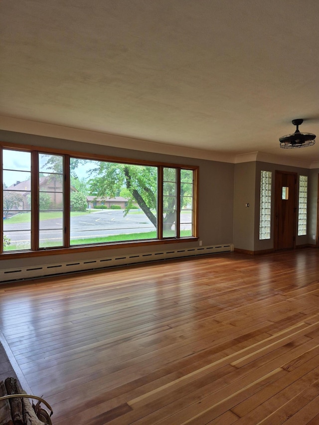 227 Summit Ave, Grantsburg, WI 54840 - unfurnished living room featuring hardwood / wood-style floors, a baseboard radiator, and baseboards