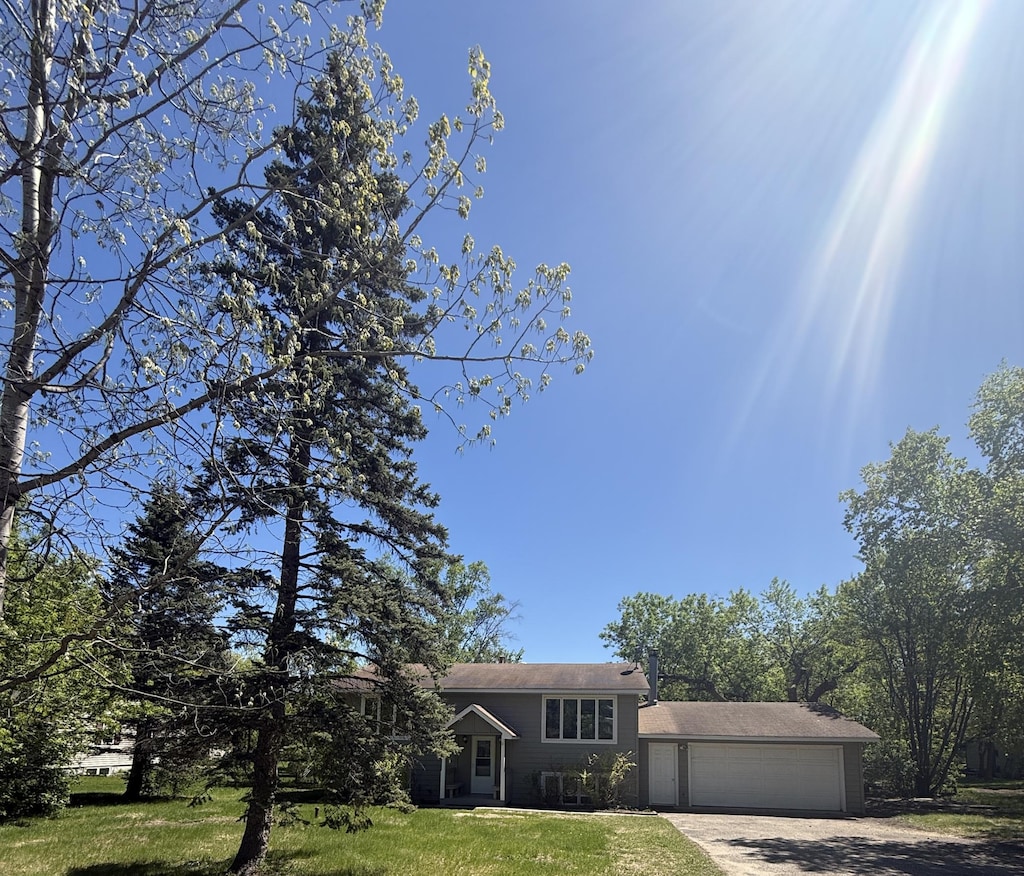 144 Circle Pines Dr NW, Bemidji, MN 56601 - tri-level home featuring driveway, a garage, and a front lawn