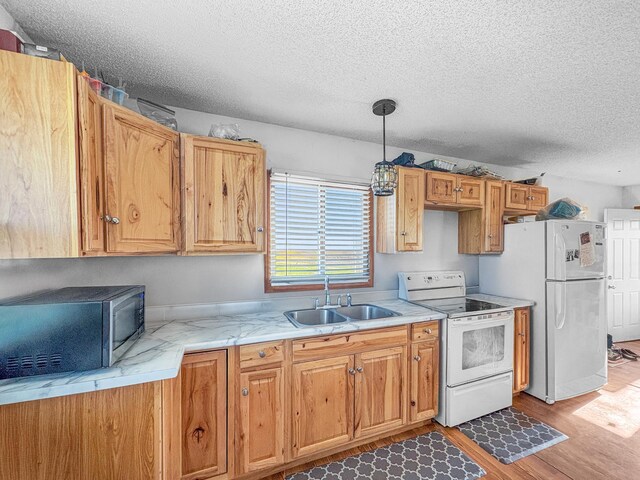 398 11 1/2 Ave, Turtle Lake, WI 54889 - kitchen with white appliances, a sink, light wood finished floors, a textured ceiling, and pendant lighting