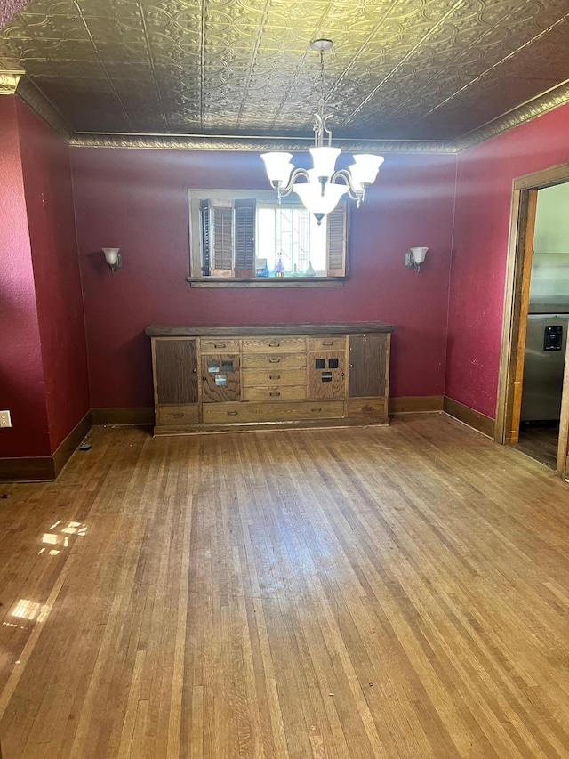 623 4th St, Madison, MN 56256 - unfurnished dining area with wood-type flooring, an ornate ceiling, a chandelier, and baseboards