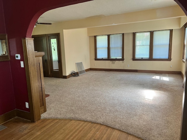 623 4th St, Madison, MN 56256 - unfurnished room featuring arched walkways, baseboards, and wood finished floors