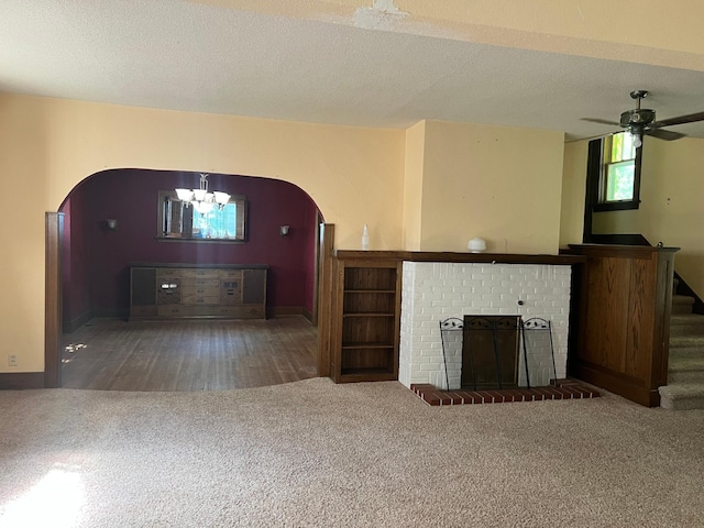 623 4th St, Madison, MN 56256 - unfurnished living room with arched walkways, carpet flooring, a chandelier, and a fireplace