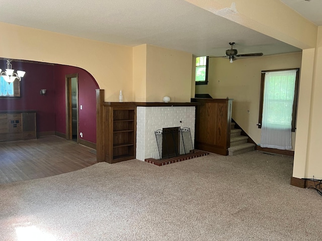 623 4th St, Madison, MN 56256 - unfurnished living room featuring carpet, a brick fireplace, ceiling fan, stairs, and baseboards