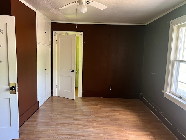 623 4th St, Madison, MN 56256 - unfurnished bedroom featuring crown molding, light wood-style floors, a textured ceiling, baseboards, and a ceiling fan