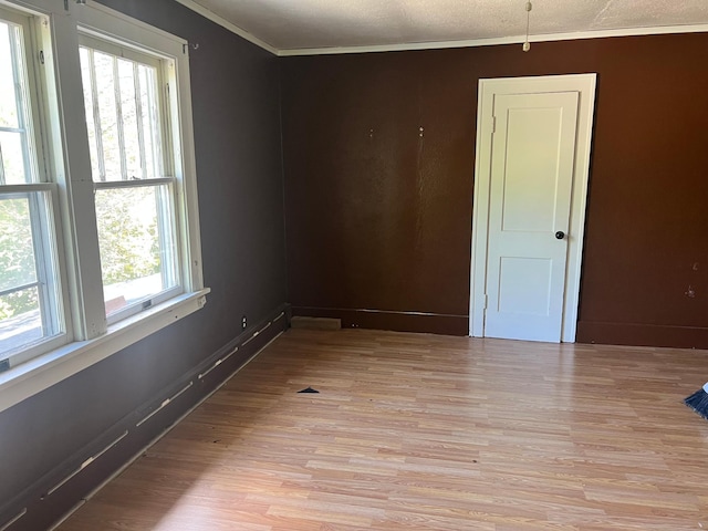 623 4th St, Madison, MN 56256 - spare room with crown molding, light wood-style floors, and baseboards