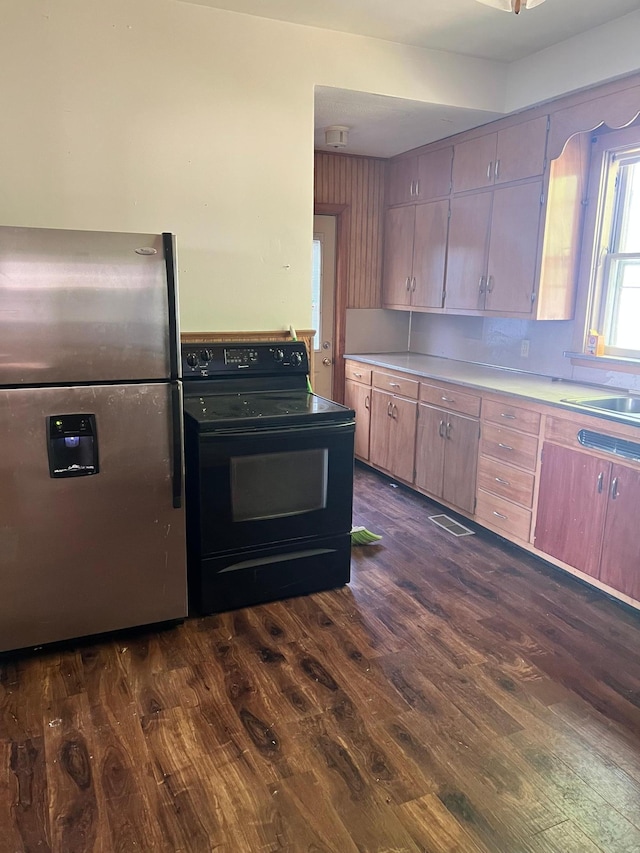 623 4th St, Madison, MN 56256 - kitchen with stainless steel fridge, black electric range oven, dark wood-style floors, light countertops, and a sink