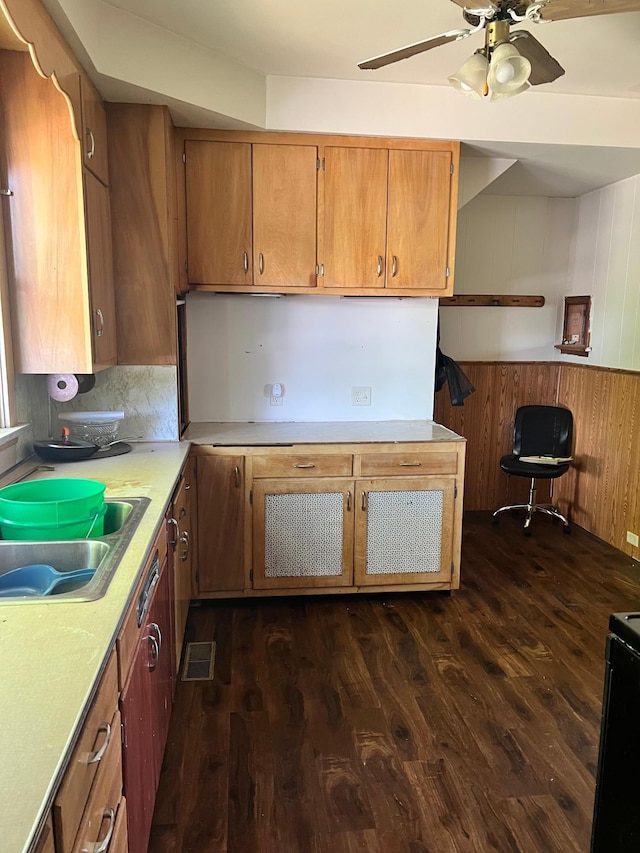 623 4th St, Madison, MN 56256 - kitchen with a sink, dark wood finished floors, light countertops, brown cabinetry, and wooden walls