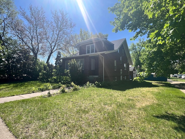 623 4th St, Madison, MN 56256 - view of front facade with brick siding and a front lawn