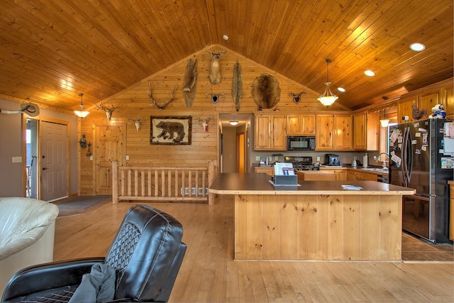 2200 405th Ave NW, Braham, MN 55006 - kitchen featuring refrigerator with ice dispenser, black microwave, open floor plan, stove, and wooden walls