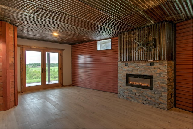 2200 405th Ave NW, Braham, MN 55006 - unfurnished living room featuring a stone fireplace, wood finished floors, and healthy amount of natural light