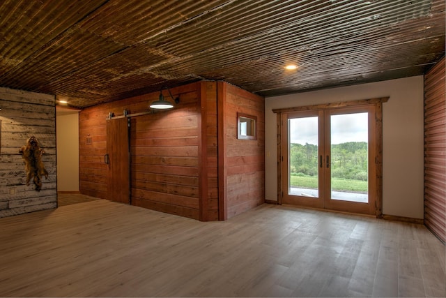 2200 405th Ave NW, Braham, MN 55006 - spare room with french doors, wooden walls, a barn door, wood finished floors, and recessed lighting