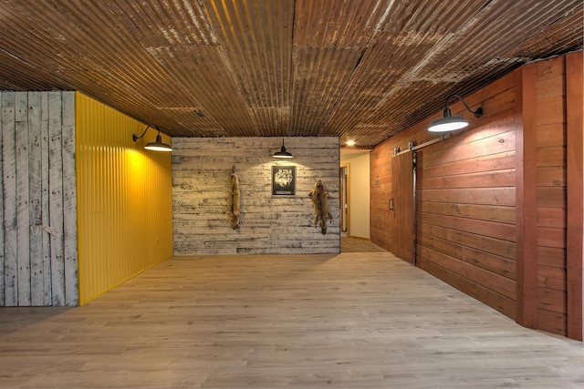 2200 405th Ave NW, Braham, MN 55006 - corridor featuring wood walls, a barn door, and wood finished floors