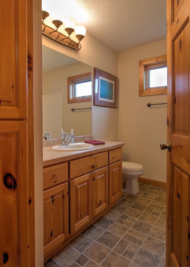 2200 405th Ave NW, Braham, MN 55006 - bathroom with vanity, a textured ceiling, and stone finish floors