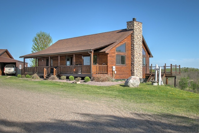 2200 405th Ave NW, Braham, MN 55006 - log-style house featuring a chimney, covered porch, a front lawn, roof with shingles, and a detached garage
