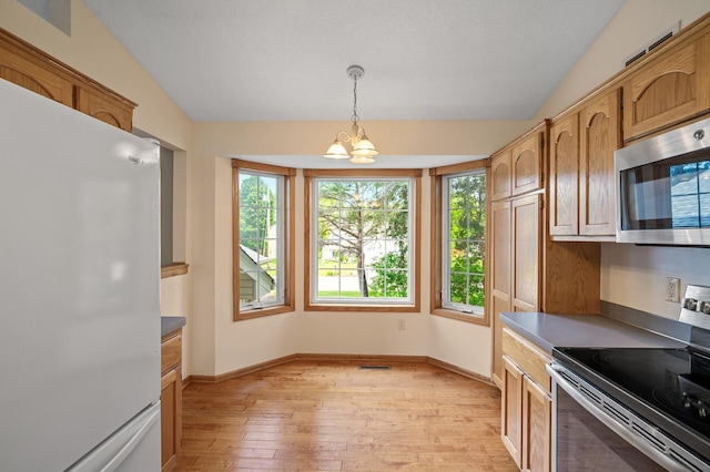 2572 91st Ln NE, Blaine, MN 55449 - kitchen featuring stainless steel appliances, light wood-style floors, a chandelier, hanging light fixtures, and baseboards