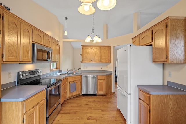 2572 91st Ln NE, Blaine, MN 55449 - kitchen with stainless steel appliances, light wood-style floors, a chandelier, a sink, and pendant lighting