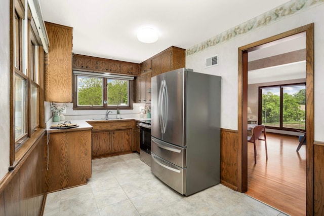 10180 County Road 43, Laketown Twp, MN 55318 - kitchen featuring freestanding refrigerator, plenty of natural light, a sink, a wainscoted wall, and brown cabinets