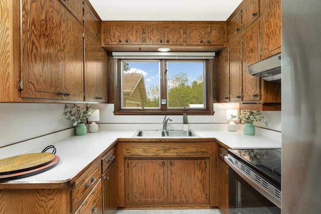 10180 County Road 43, Laketown Twp, MN 55318 - kitchen with a sink, under cabinet range hood, stainless steel appliances, and brown cabinetry