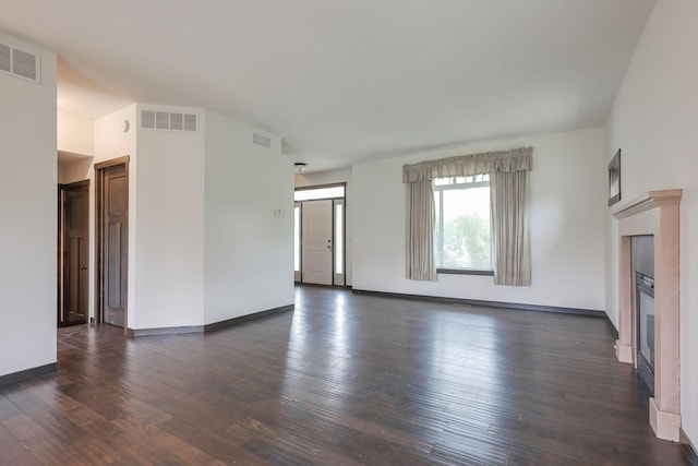 12396 67th St NE, Otsego, MN 55330 - unfurnished living room with dark wood-style floors, a glass covered fireplace, and baseboards