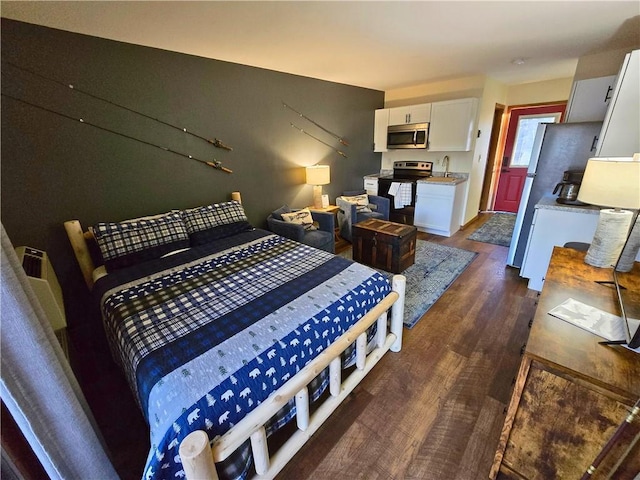 15326 Birch Point Rd, Lenroot Twp, WI 54843 - bedroom featuring dark wood-type flooring, freestanding refrigerator, and a sink