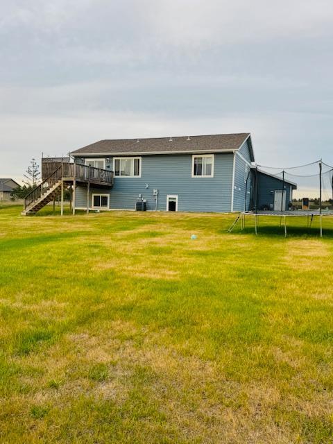 1320 Whiting Rd NW Unit 41, Bemidji, MN 56601 - back of house with a trampoline, a deck, stairway, and a yard