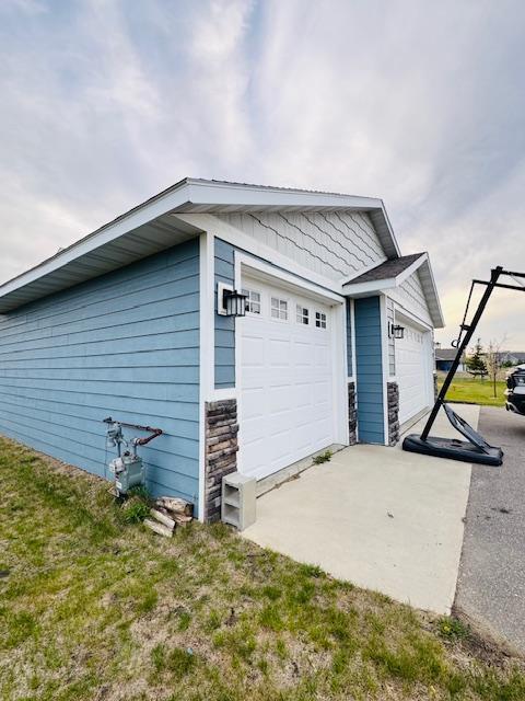 1320 Whiting Rd NW Unit 41, Bemidji, MN 56601 - view of side of home featuring stone siding and a garage