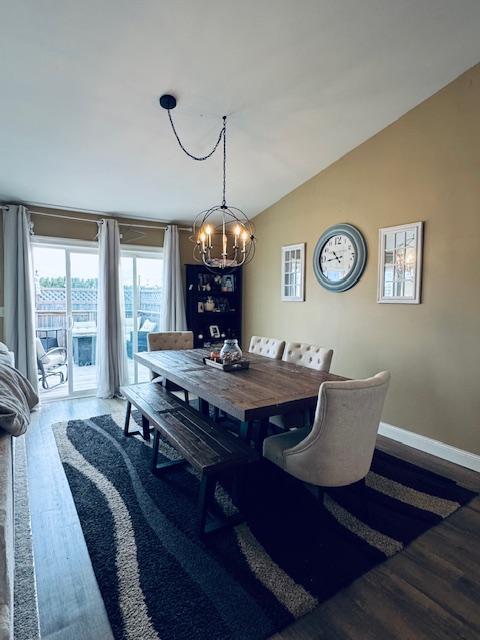 1320 Whiting Rd NW Unit 41, Bemidji, MN 56601 - dining space featuring a chandelier, wood finished floors, lofted ceiling, and baseboards