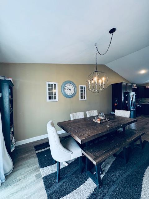 1320 Whiting Rd NW Unit 41, Bemidji, MN 56601 - dining area with dark wood-style flooring, a chandelier, baseboards, and vaulted ceiling