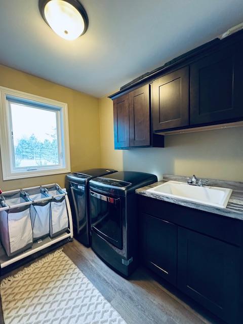 1320 Whiting Rd NW Unit 41, Bemidji, MN 56601 - laundry room with separate washer and dryer, cabinet space, and light wood finished floors