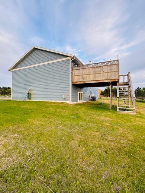 1320 Whiting Rd NW Unit 41, Bemidji, MN 56601 - rear view of property with a wooden deck, a lawn, stairs, and cooling unit