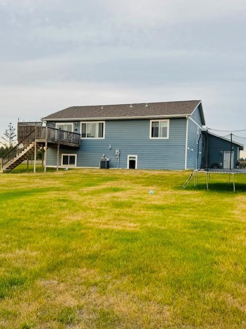 1320 Whiting Rd NW Unit 41, Bemidji, MN 56601 - rear view of house featuring a trampoline, a wooden deck, stairway, and a yard