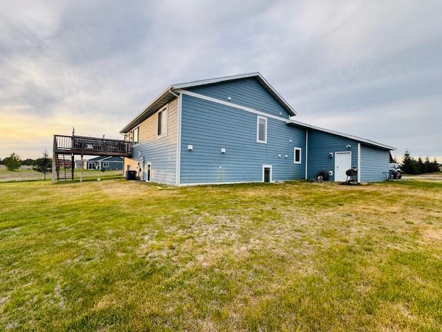 1320 Whiting Rd NW Unit 41, Bemidji, MN 56601 - rear view of house featuring a deck, a lawn, and central AC