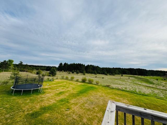 1320 Whiting Rd NW Unit 41, Bemidji, MN 56601 - view of grassy yard with a trampoline and a view of countryside