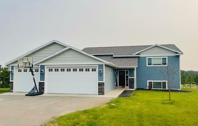 1320 Whiting Rd NW Unit 41, Bemidji, MN 56601 - tri-level home with a garage, a front yard, concrete driveway, stone siding, and a shingled roof